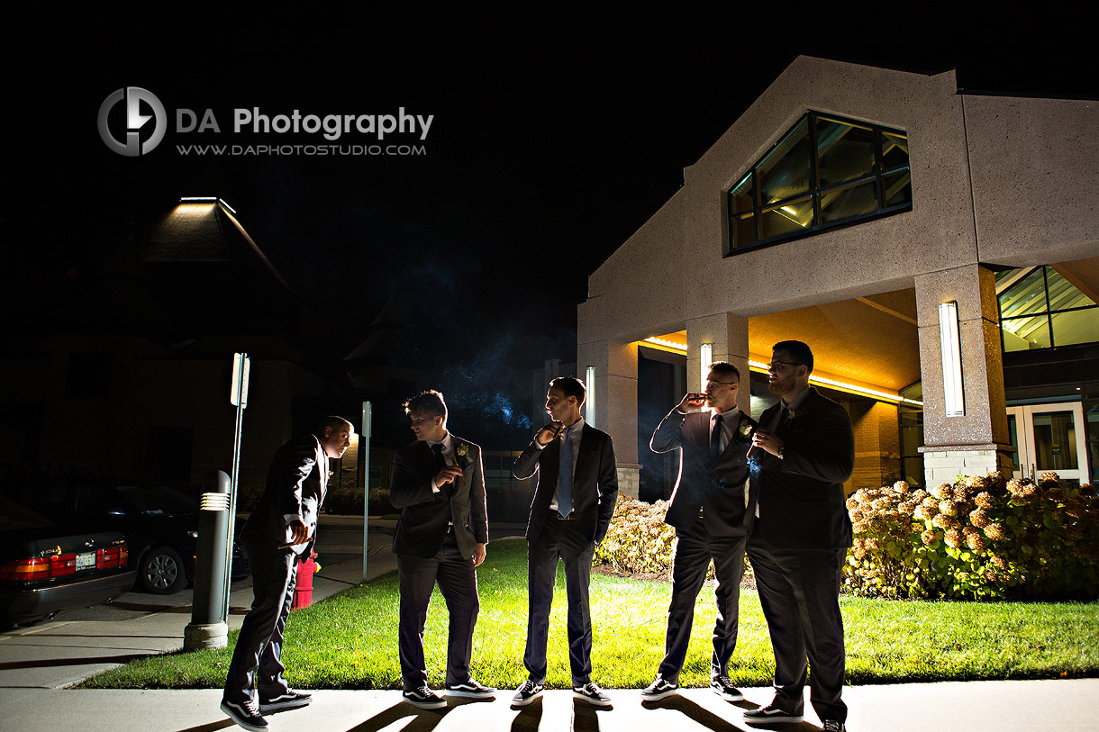 Nighttime portrait of Groomsman smoking cigars