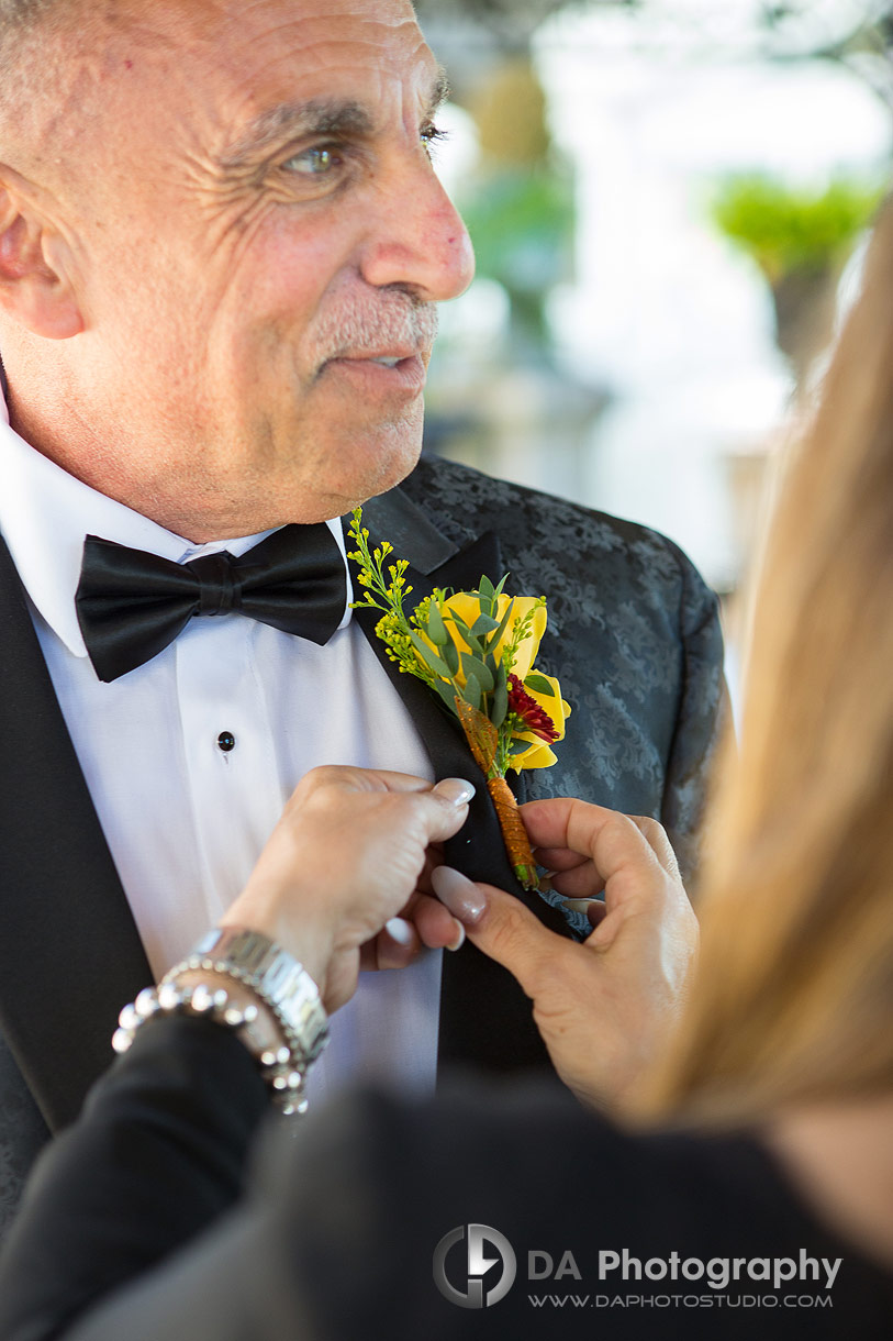 Groom getting his boutonniere flower pinned