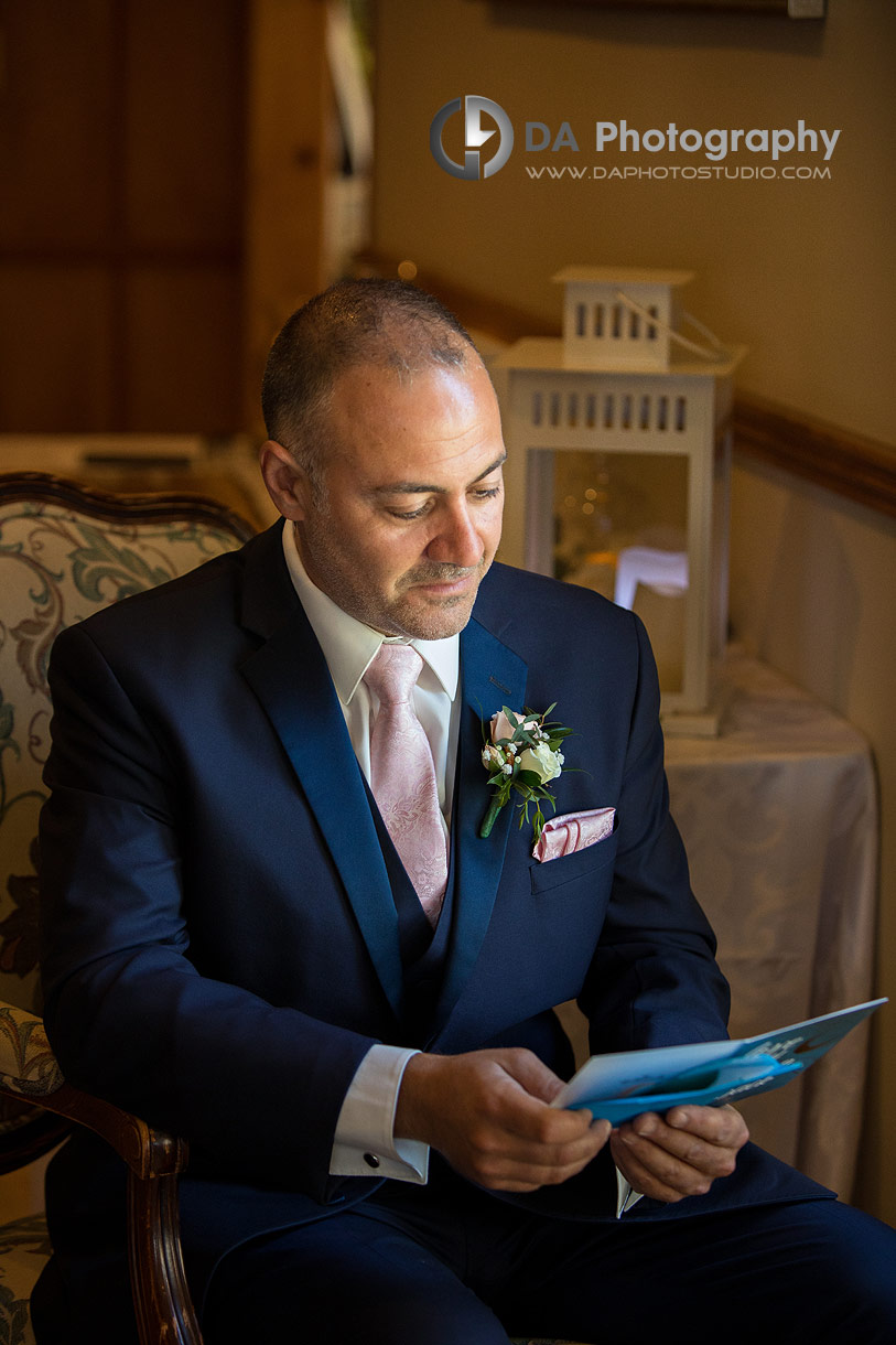 Groom reading a letter at Waterstone Estates and Farms