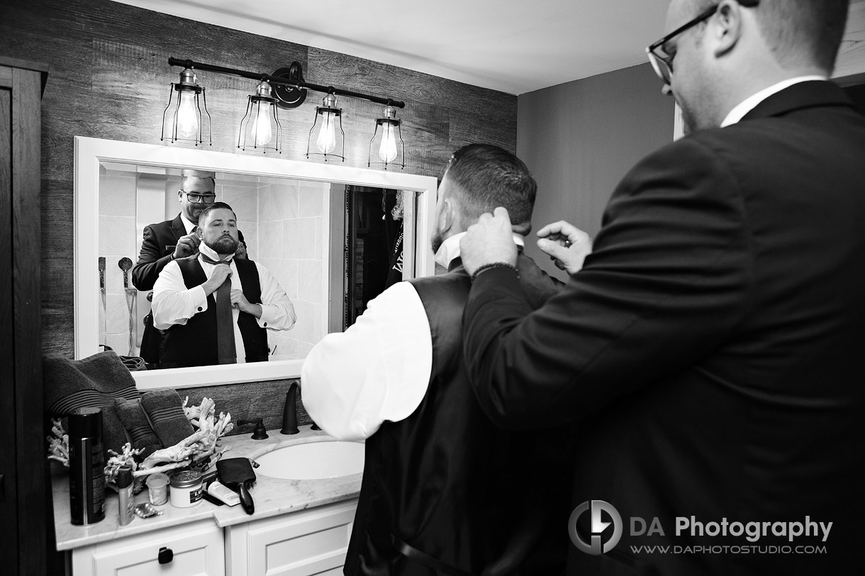 Groom getting ready with the help from his groomsmen