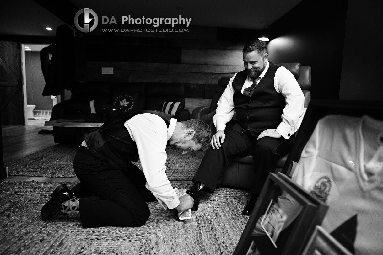 Best Man polishing shoes to his groom