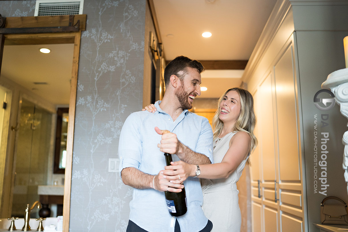 Engaged couple opening champagne