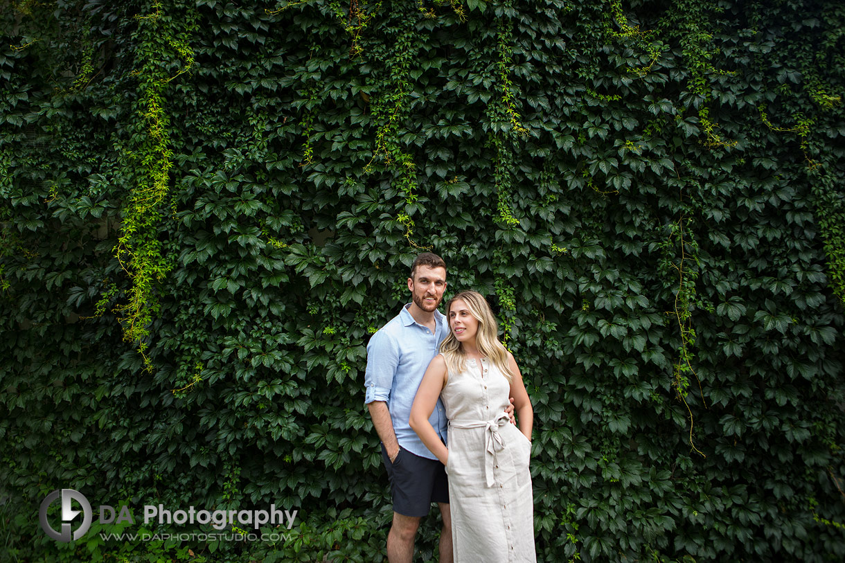 Photo of a couple in front of a ivy wall