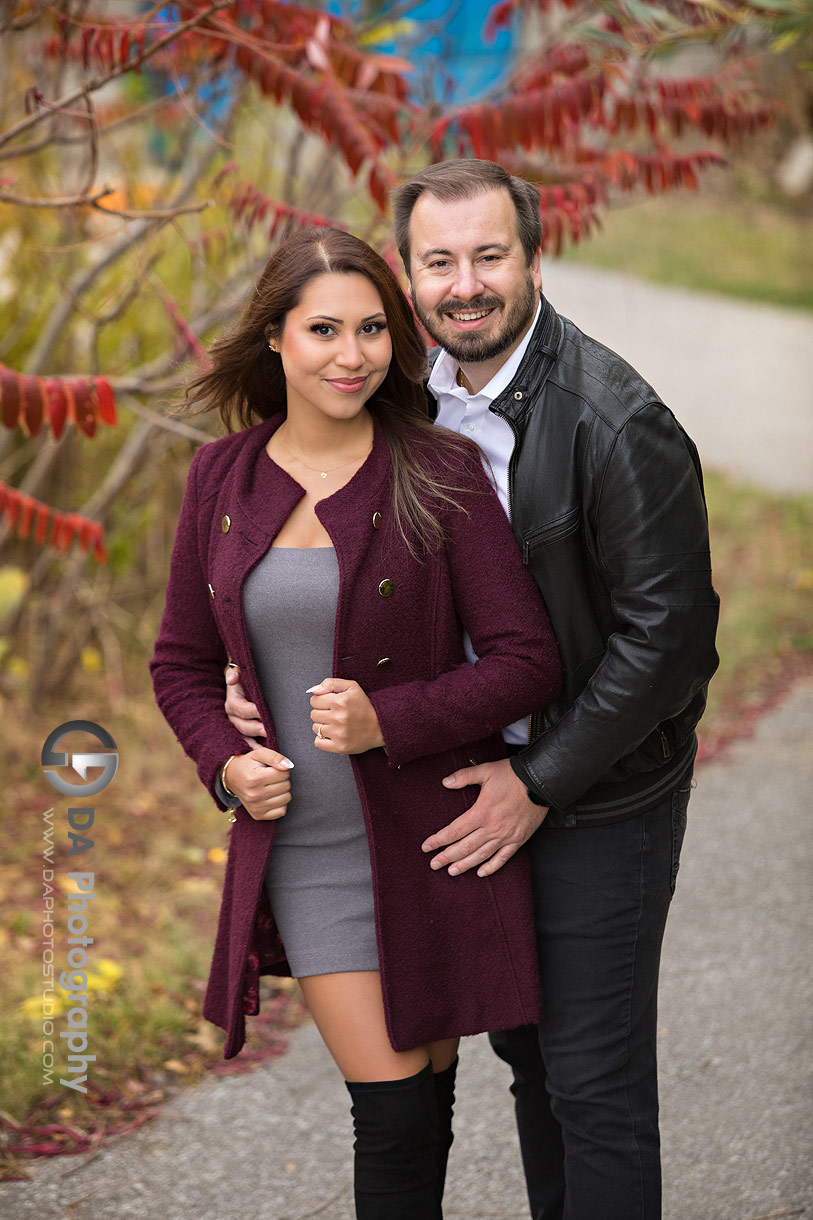 Intimate engagement photo under Humber Bay Arch Bridge in fall