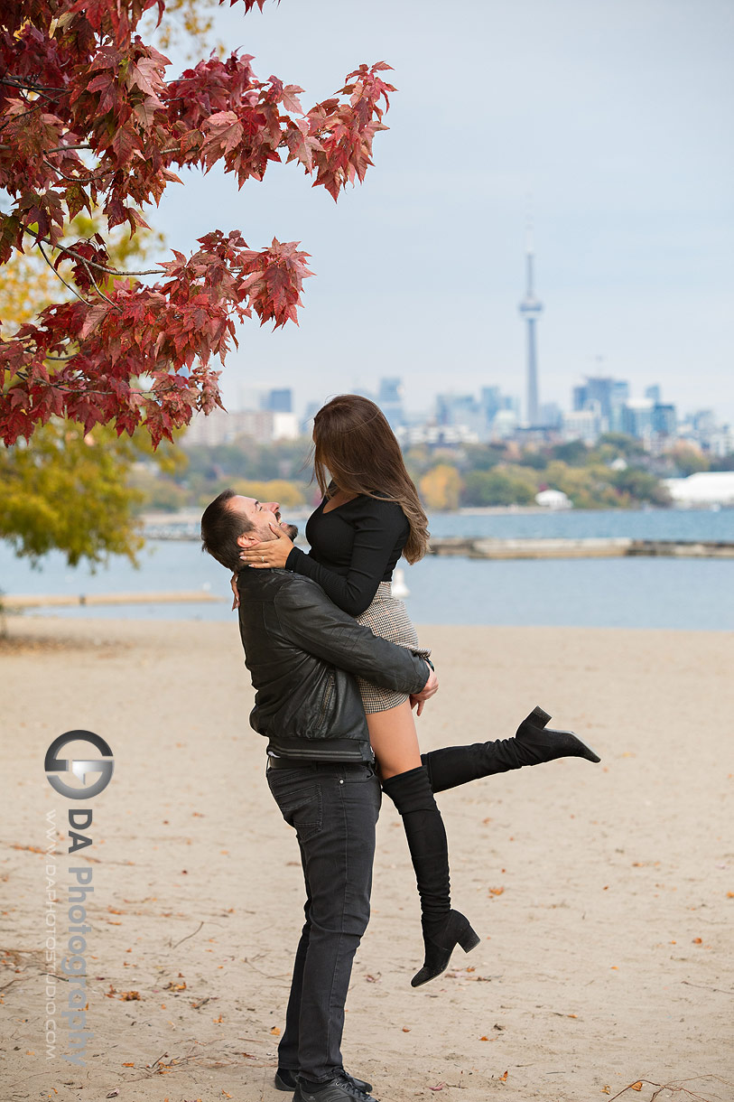 Intimate engagement photo on Toronto Beach with city skyline