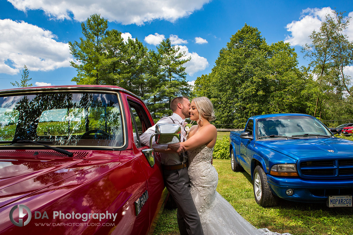 Bride and groom photo by their vintage cars