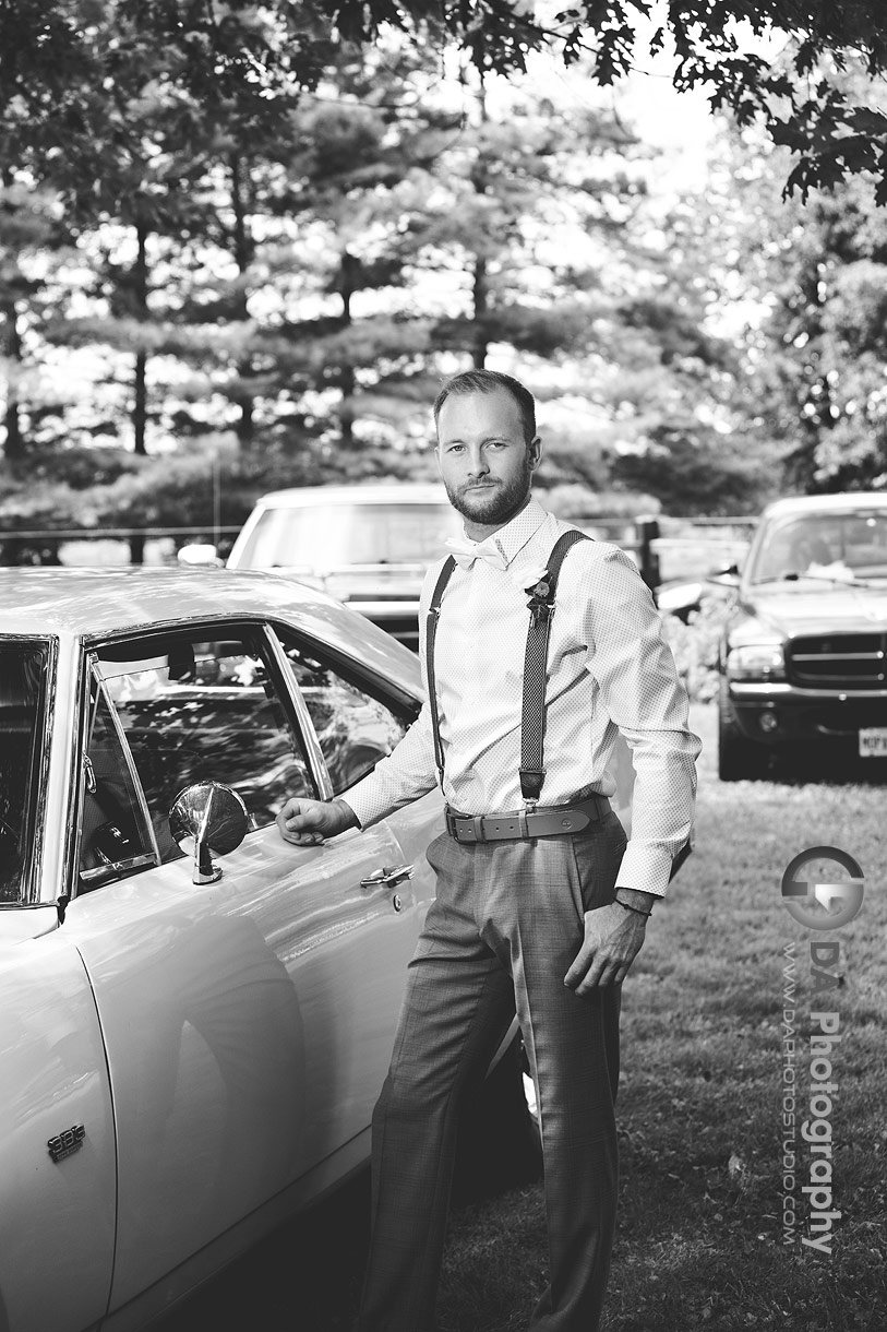 Photo of a groom next to his vintage car