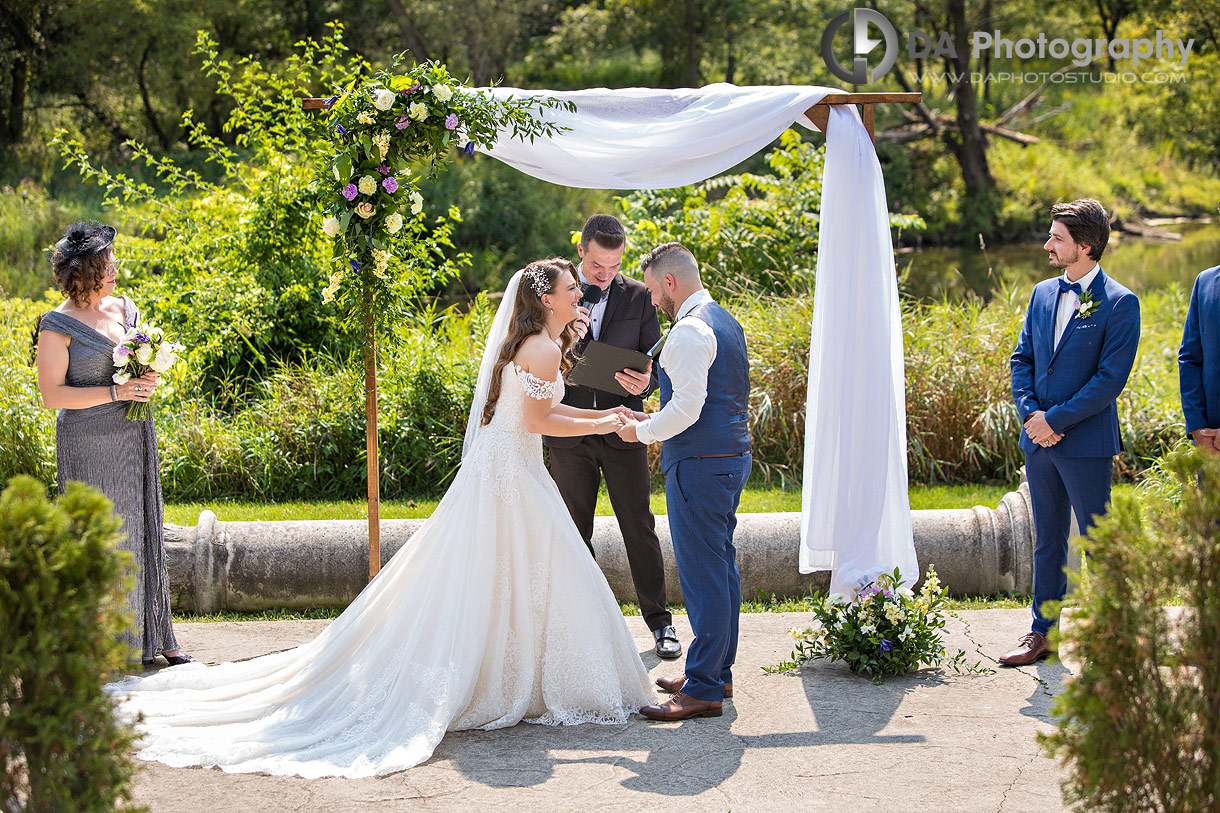 Couple exchanges vows during a boho-style outdoor ceremony at the amphitheatre at NithRidge Estates surrounded by forest and natural greenery