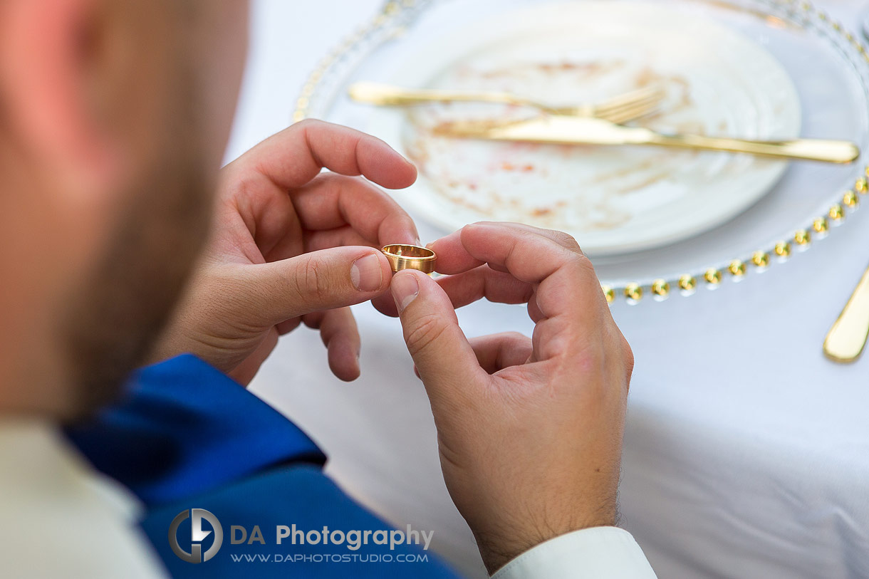 Photo of a Groom looking at his wedding ring engraving