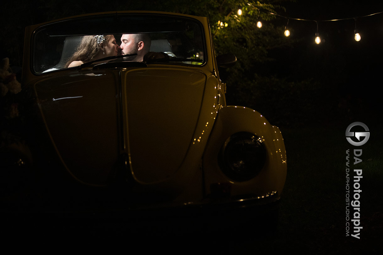 Intimate photo of bride and groom in yellow beetle car