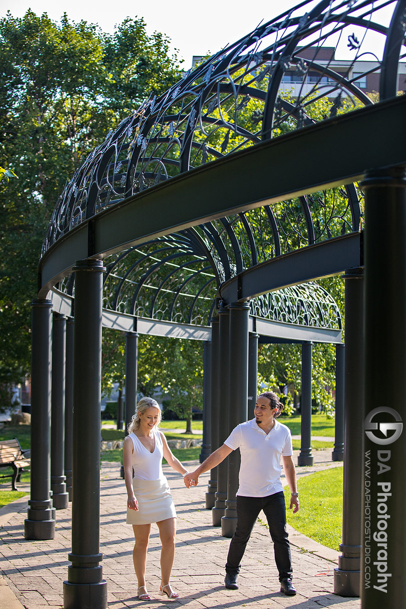 Couple walking hand in hand through Westwood Park during their waterfront engagement session in Oakville