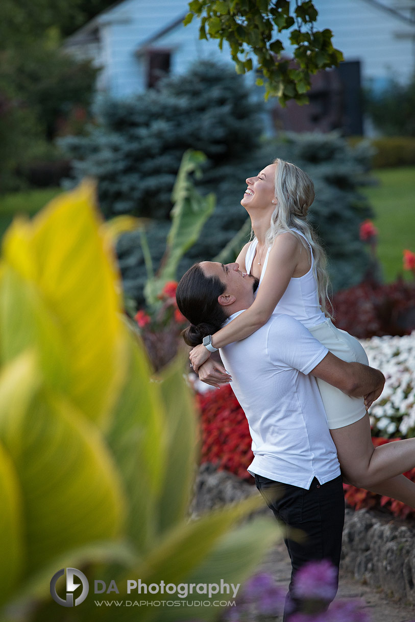 Couple laughing together while surrounded by colourful garden flowers