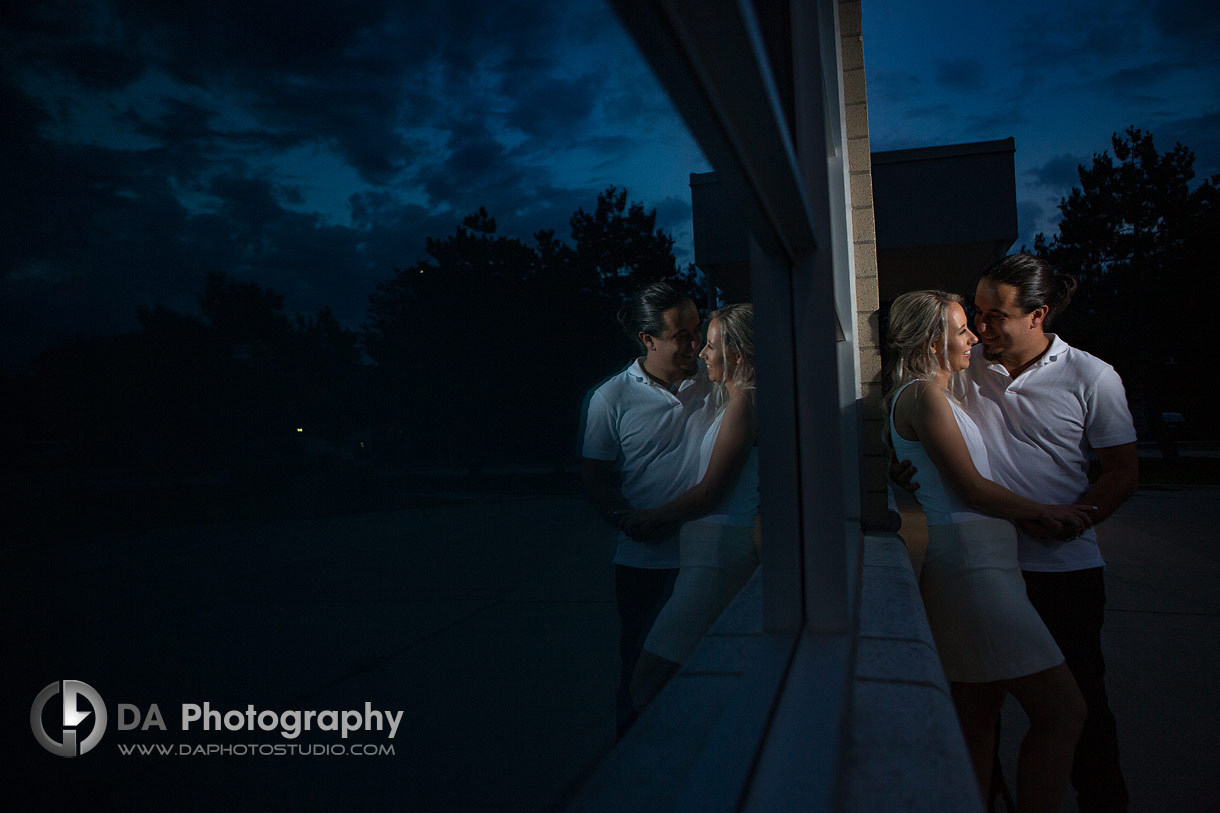 Twilight engagement photo with deep blue sky behind the couple at their high school