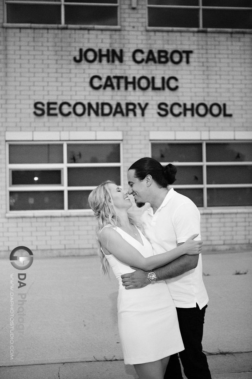 Black and white engagement photo of the couple in front of the school courtyard