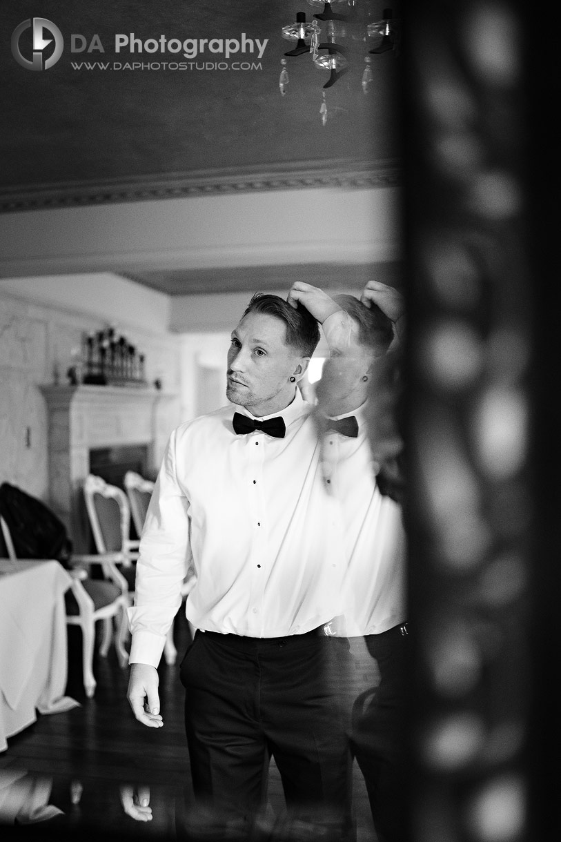 Photo of a Mirror reflection of groom fixing his hair