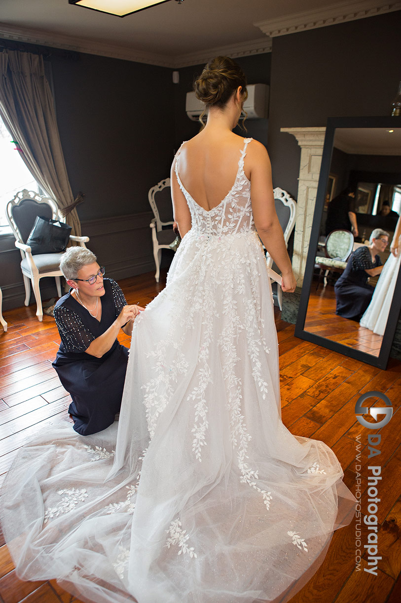 Photo of a Bride get helped by her mom fixing her dress