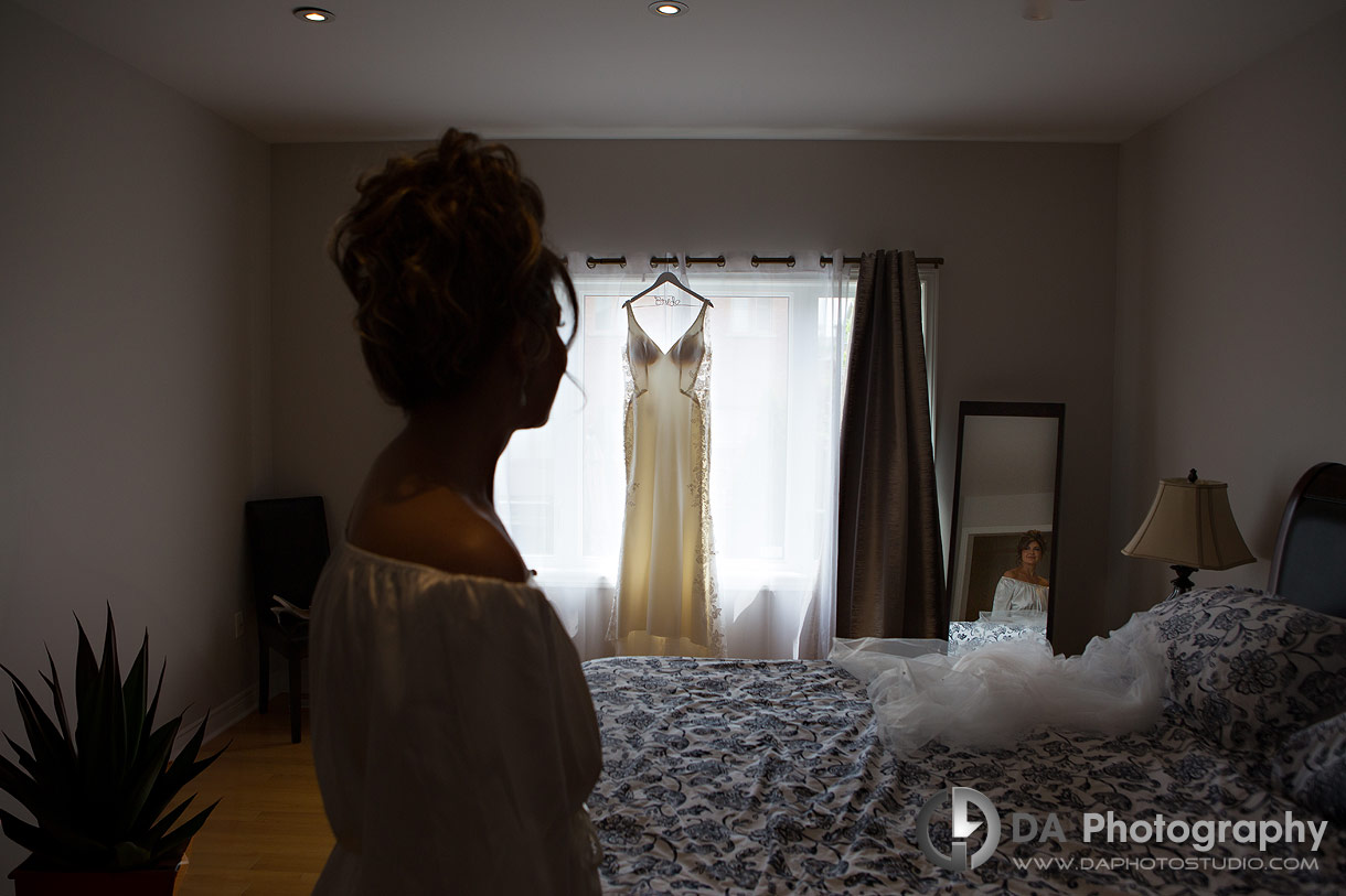 Bride looking at her wedding dress showcasing her reflection in the mirror