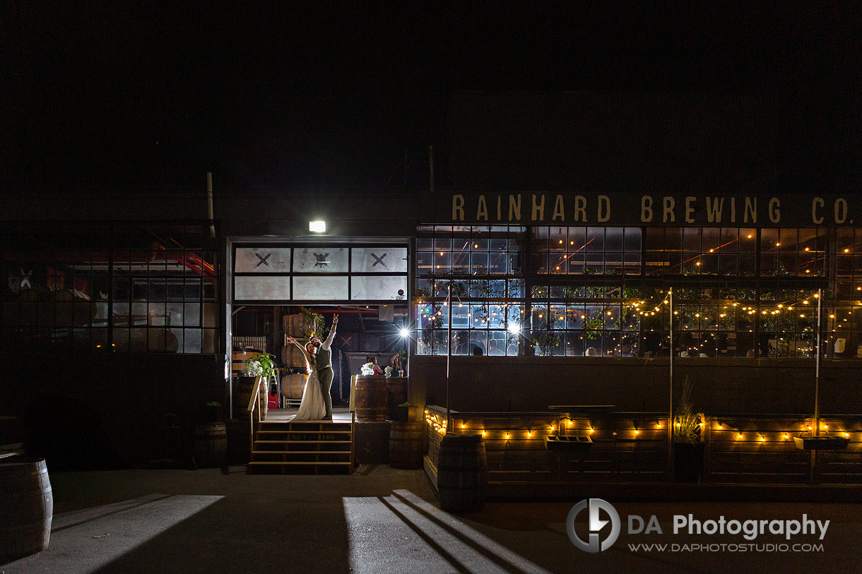 Night photo of a bride at groom in front of a brewery