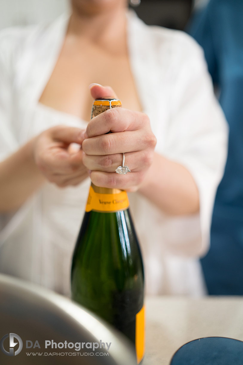 Photo of a bride opening a champagne
