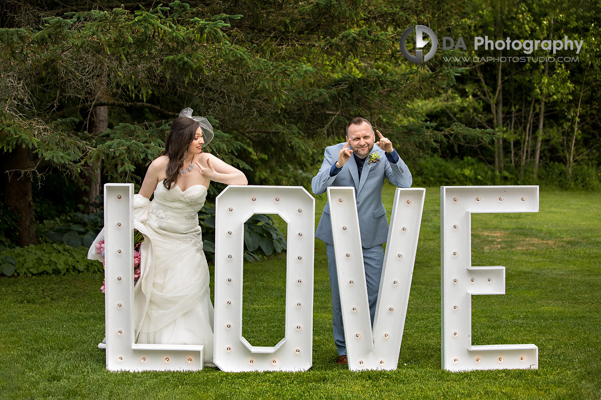 Fun photo of a bride and groom by LOVE letters Fun photo of a bride and groom by LOVE letters