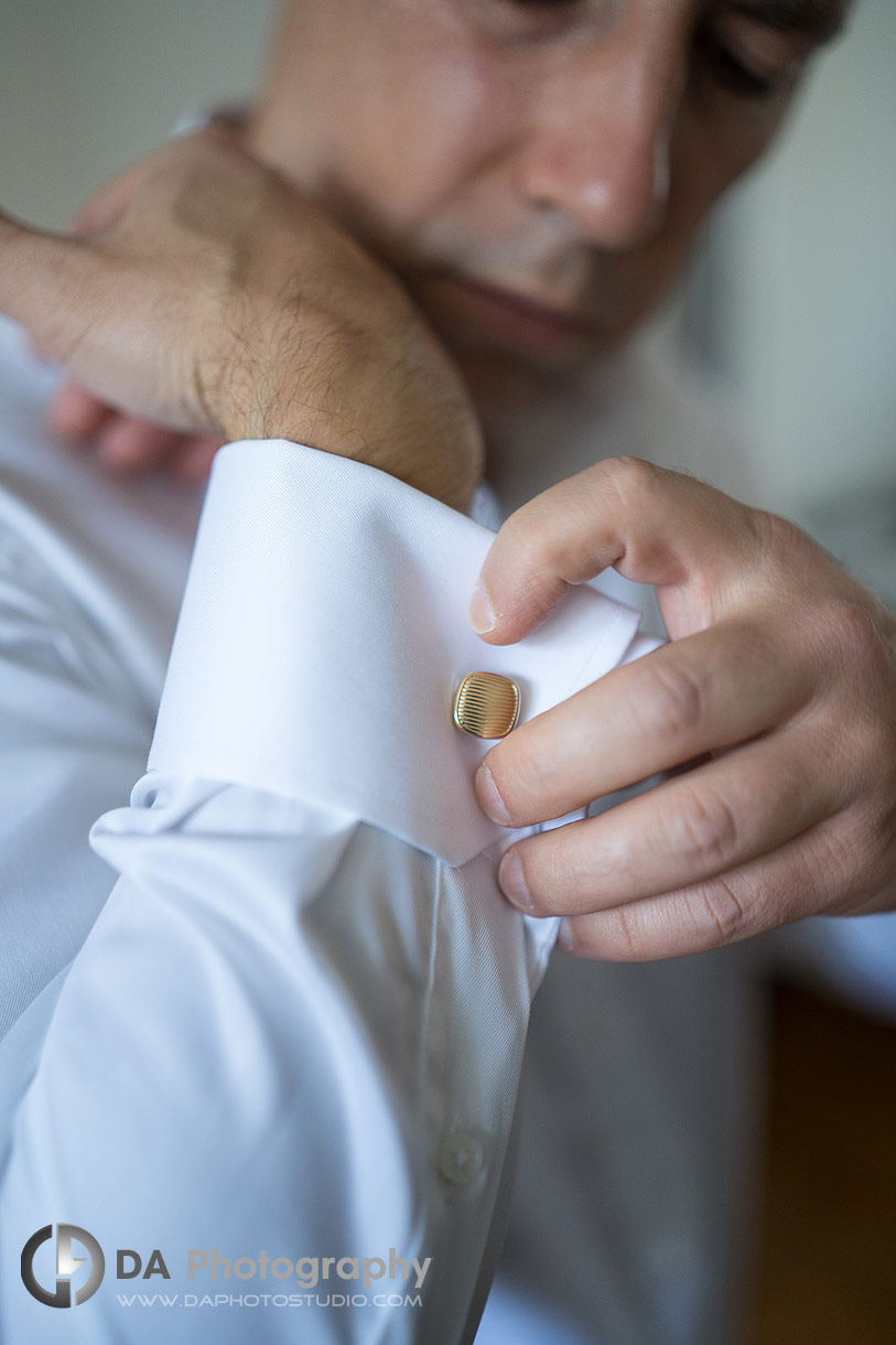 Photo of a groom fixing his cufflinks Photo of a groom fixing his cufflinks
