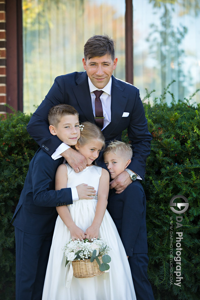 Photo of a groom hugging the ring boys and flower girl Photo of a groom hugging the ring boys and flower girl