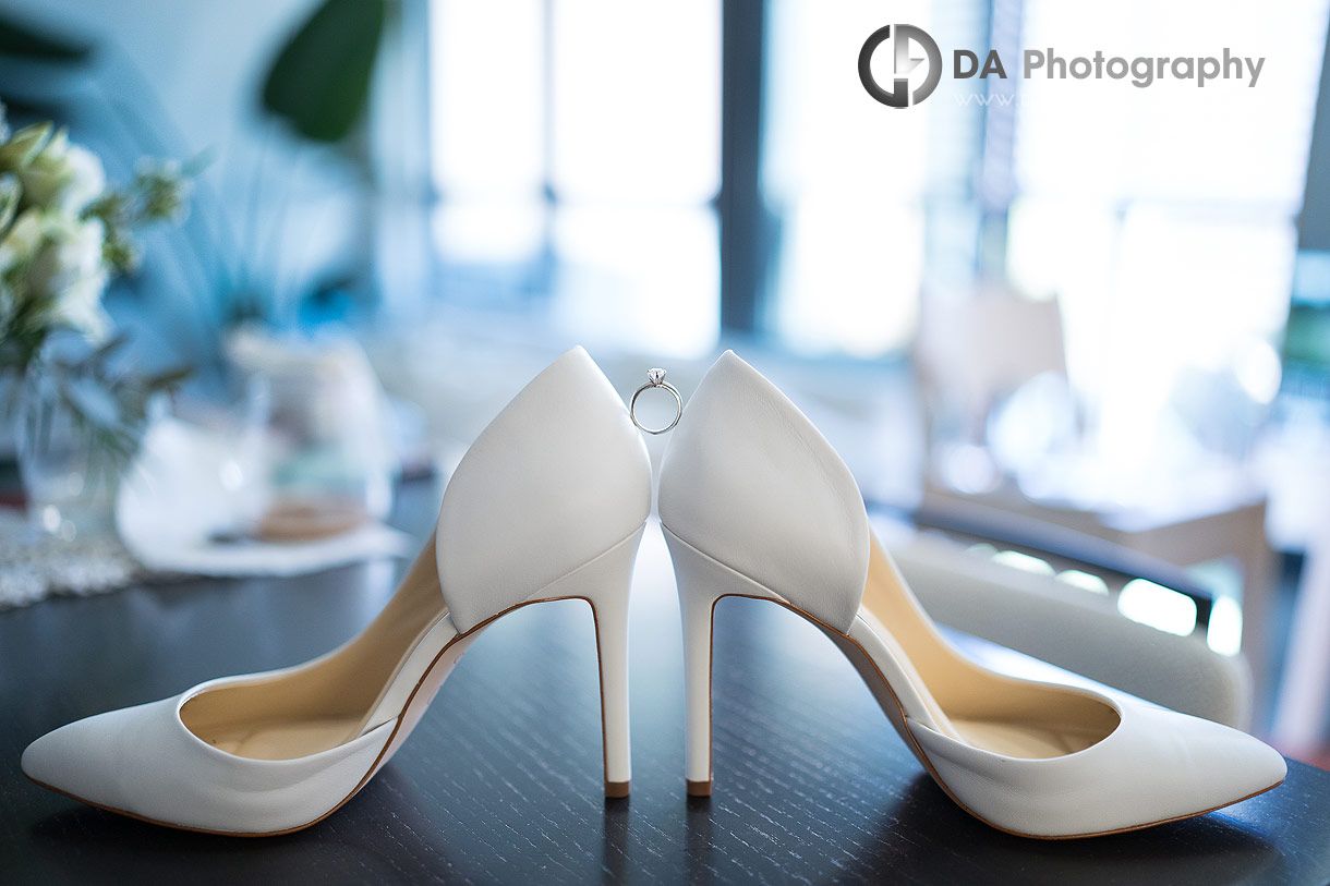 Photo of an engagement ring in-between wedding shoes Photo of an engagement ring in-between wedding shoes