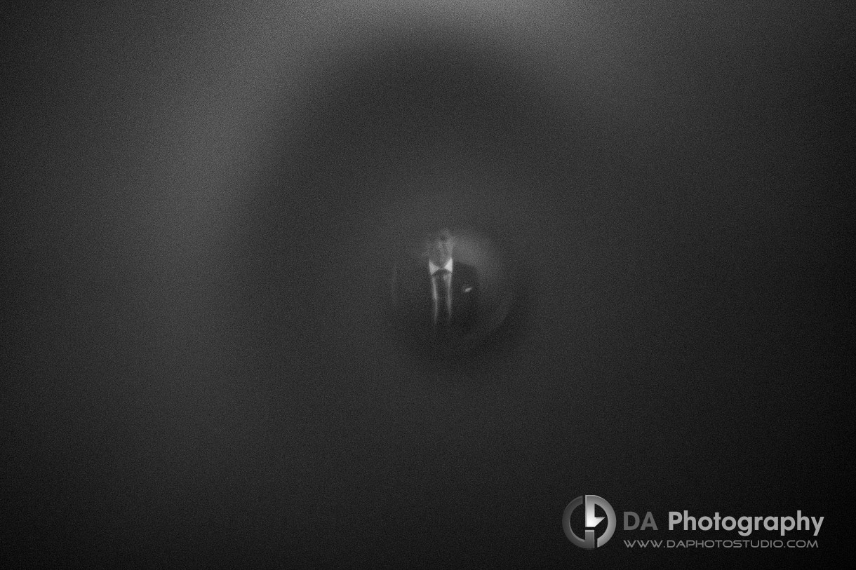 Photo of a groom through door viewer Photo of a groom through door viewer