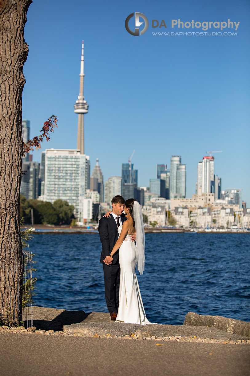 Photo of a Bride and Groom by the lake with CN Tower in the background Photo of a Bride and Groom by the lake with CN Tower in the background
