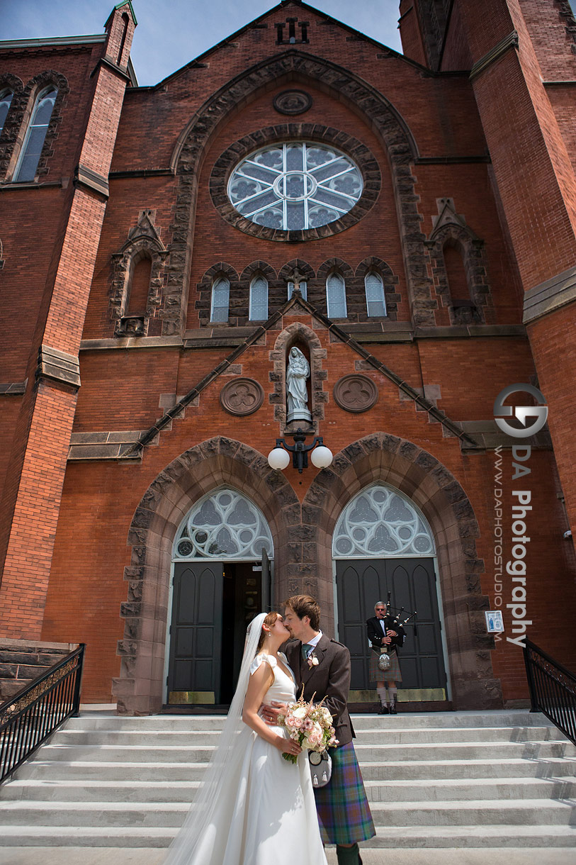 Photo of a bride and groom in front of St. Mary’s Church accompany by Pipe Player in Scottish Kilt