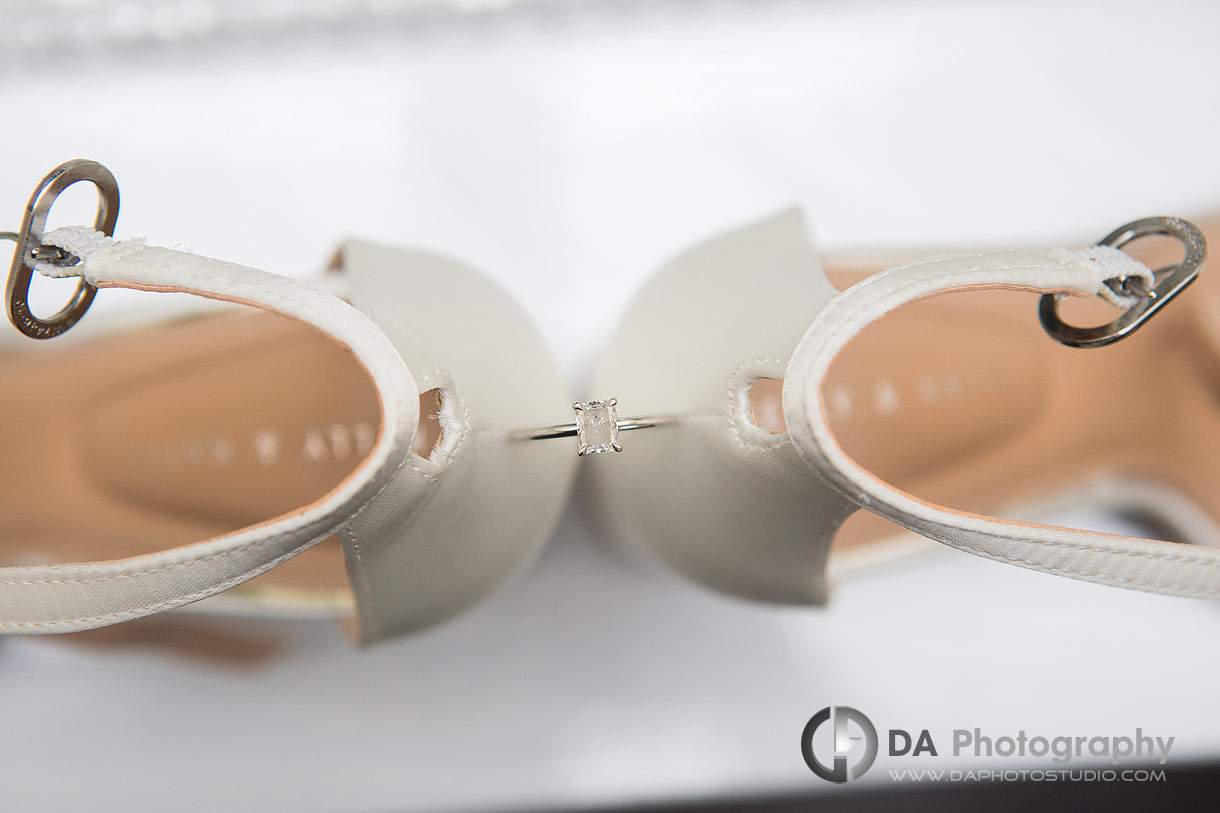 Photo of a engagement ring in between bride's shoes Photo of a engagement ring in between bride's shoes