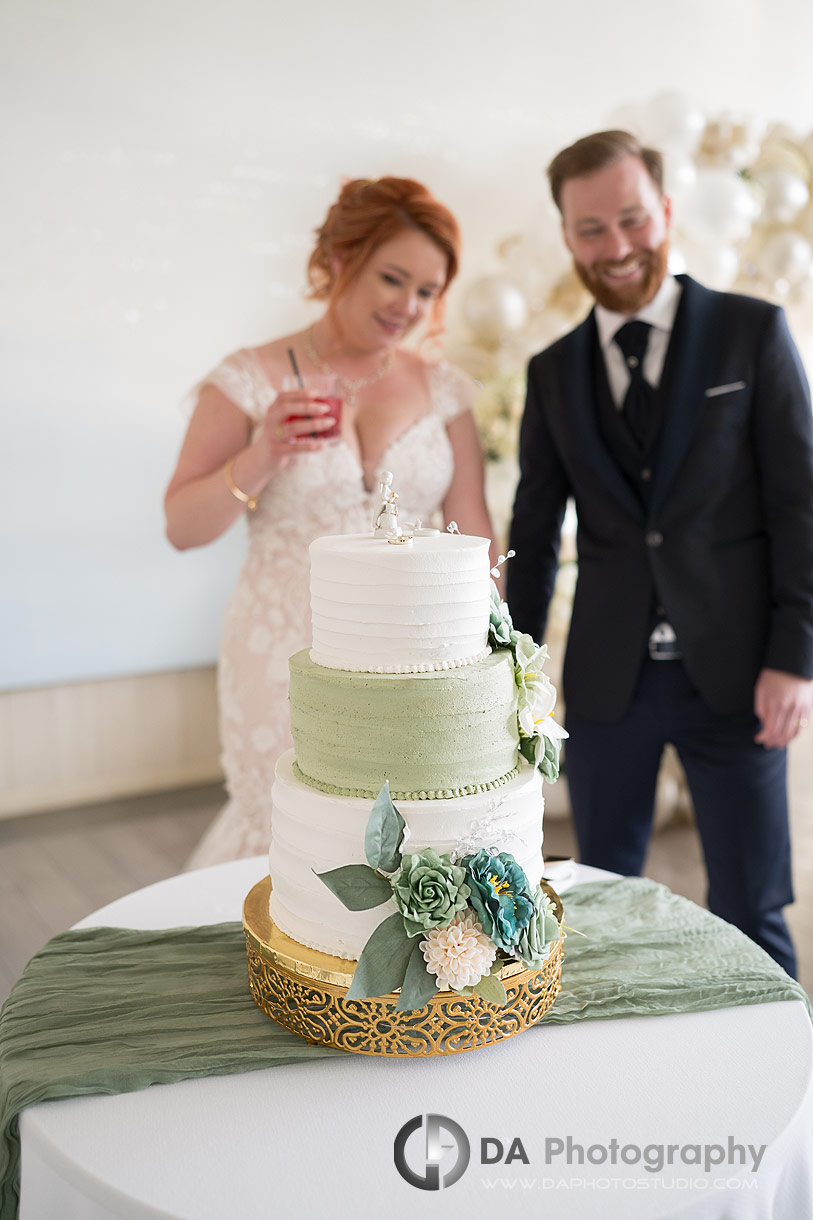 Photo of a bride and Groom looking at their wedding cake