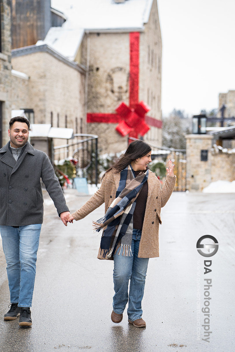 Photo of recently engaged couple walking in front of Elora Mill 